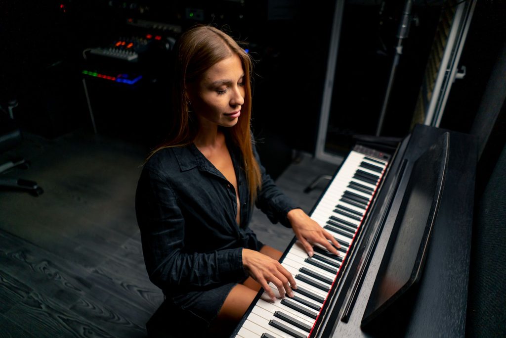 Pianistka igra digitalni klavir v glasbenem studiu